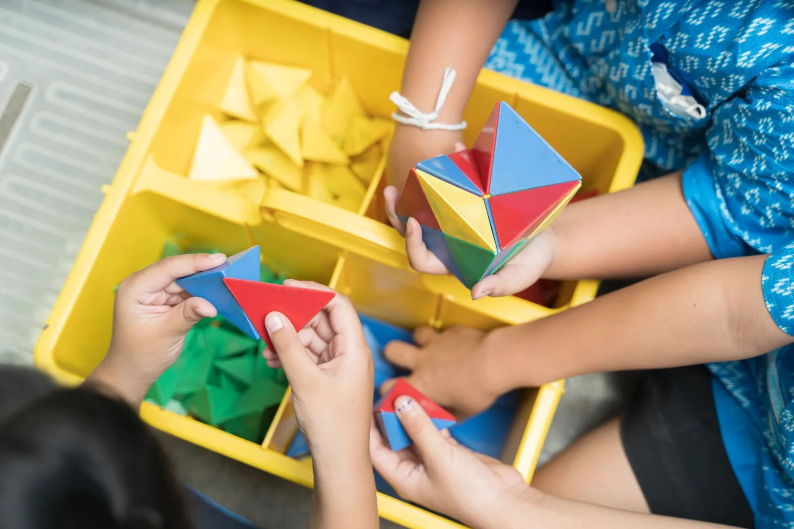 Children building geometric shapes together
