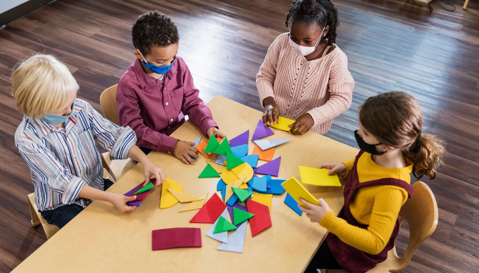 Kids building colourful shapes at a table